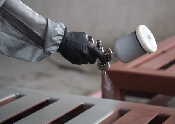 travailleur pulverisant de la peinture en poudre a partir d une vue laterale du pistolet